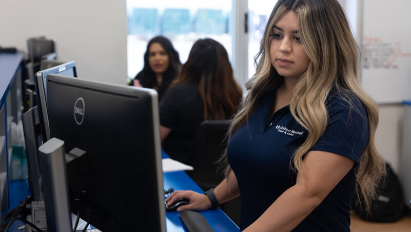 Plusieurs femmes reprÃ©sentantes du service client en chemises bleu marine travaillent sur leurs ordinateurs.